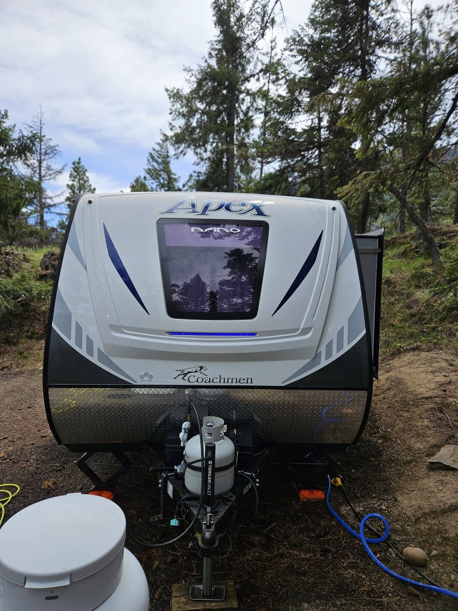 Clean Apex travel trailer at a wooded campsite